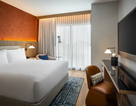 Modern Guest Room at The Nobleman Hotel in Fort Worth, TX with King Bed, Desk, Chair and Television.