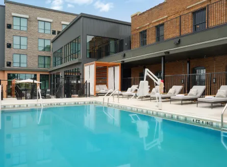 Outdoor Pool with Chaise Lounge Chairs and a Cabana at The Nobleman Hotel in Fort Worth, TX.